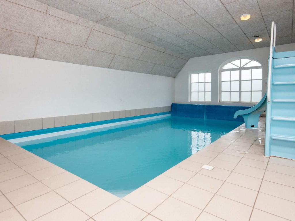 a swimming pool with blue water in a room at 4 star holiday home in Ulfborg in Ulfborg