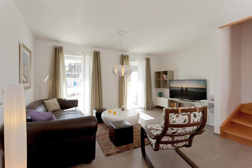 a living room with a couch and a chair at Haus 163, Lärchenweg 8 in Ostseebad Karlshagen