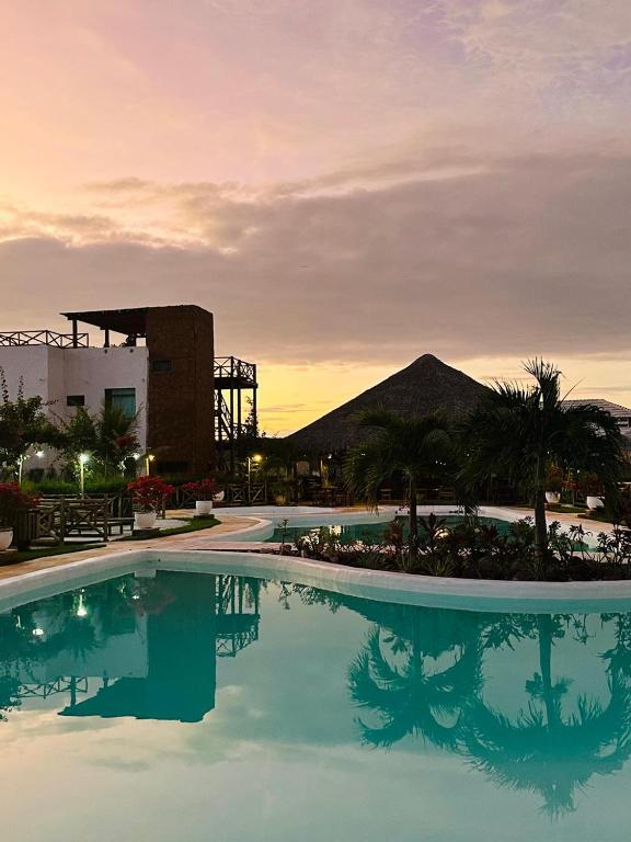 a large swimming pool with a mountain in the background at Chale Praia Barrinha in Barrinha