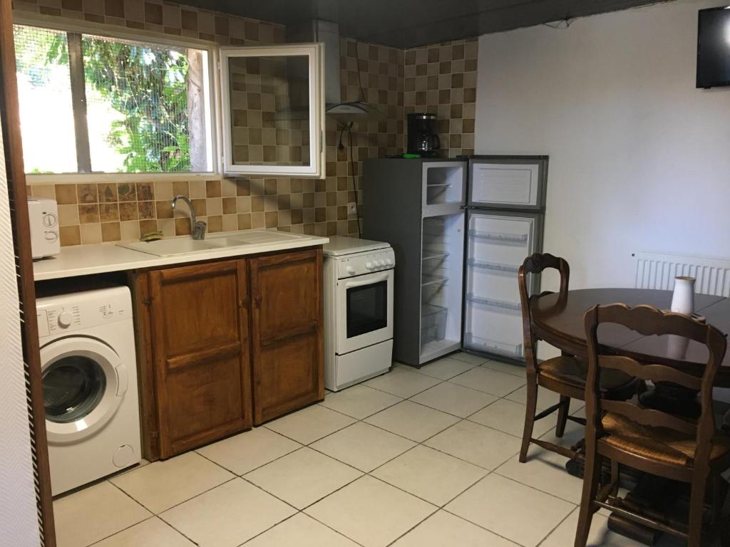 Il comprend une cuisine équipée d'un lave-linge, d'un évier et d'une table. dans l'établissement Jean, à Valence