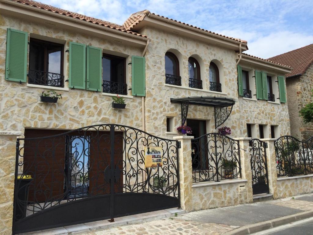 a house with a gate and green shutters at Chatihotes in Châtillon