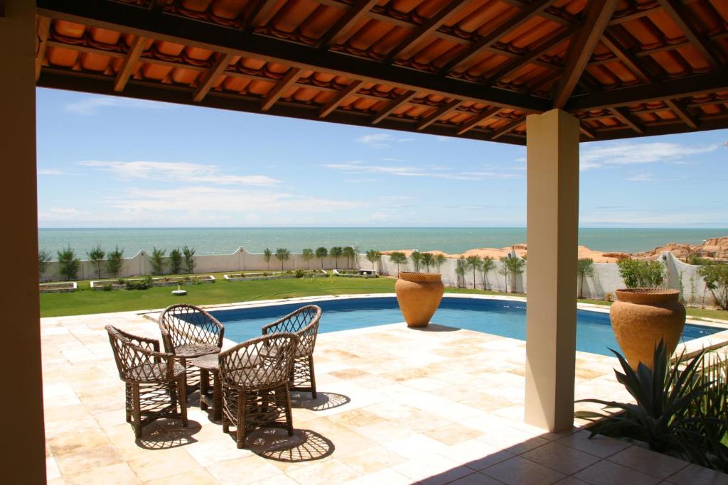 a patio with chairs and a view of the ocean at Aqua Villa by Garvetur in Beberibe