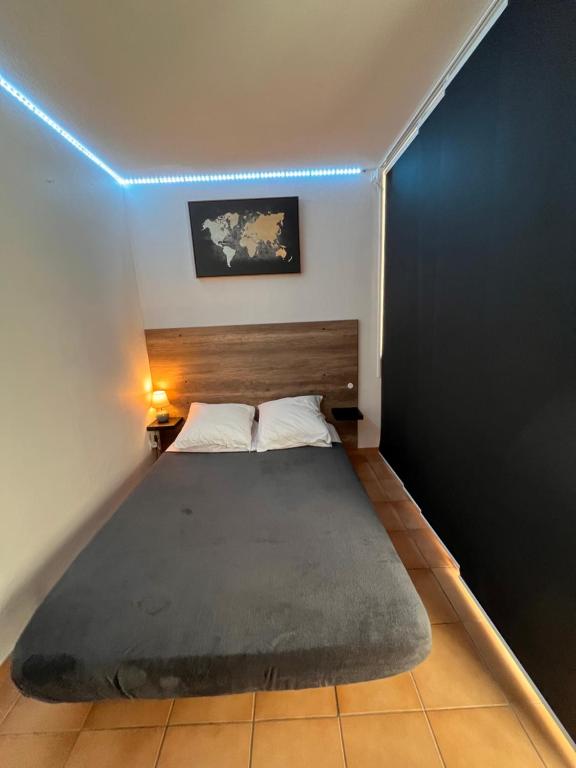 - une petite chambre avec un lit bleu clair dans l'établissement Location curistes et vacanciers, à Amélie-les-Bains-Palalda