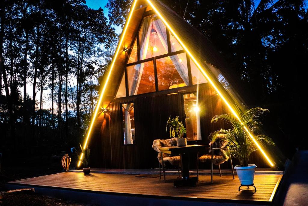 a cabin with lights on the deck at night at Chalé Maloca in Cariry