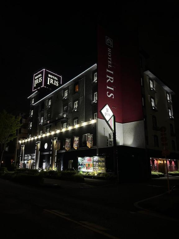 a tall building with lights on it at night at Hotel IRIS -アイリス- in Osaka