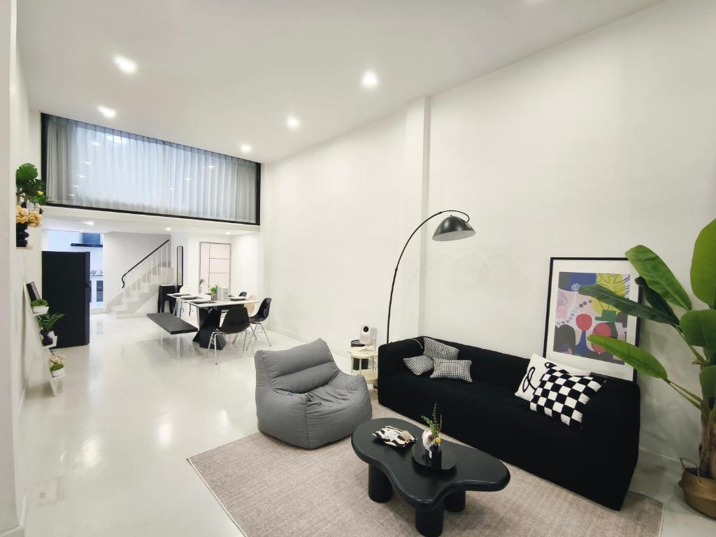 a living room with a black couch and a table at Fivehouse Silom1 - City heart - Silom -BTS MRT 2min - lumpini park - bnh in Bangkok