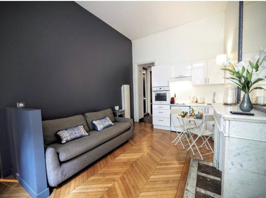 un salon avec un canapé et une cuisine dans l'établissement Studio confortable et moderne au cœur de Paris, à Paris