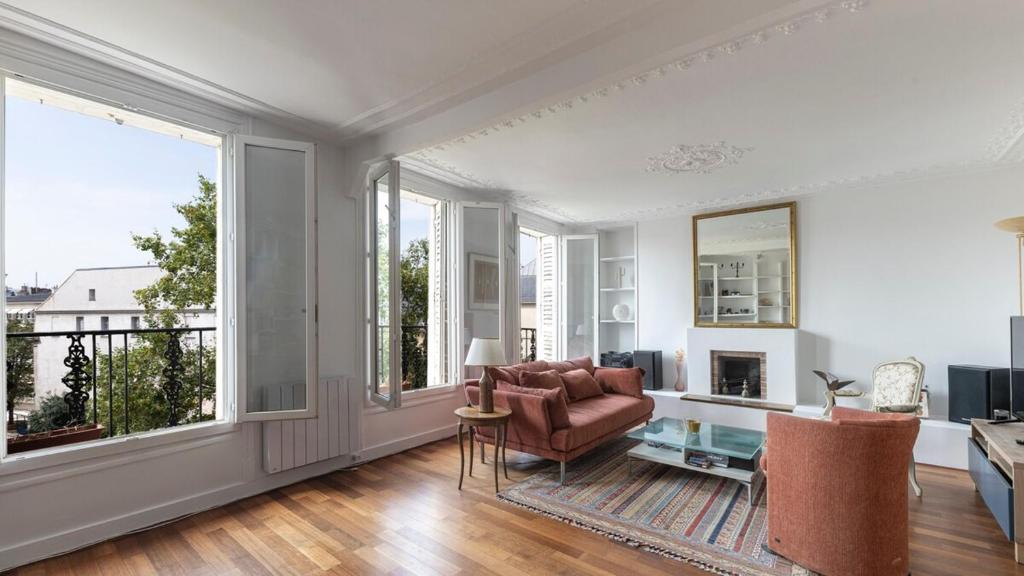 un salon avec un canapé et une cheminée dans l'établissement Spacieux au coeur du Marais | 4 personnes, à Paris