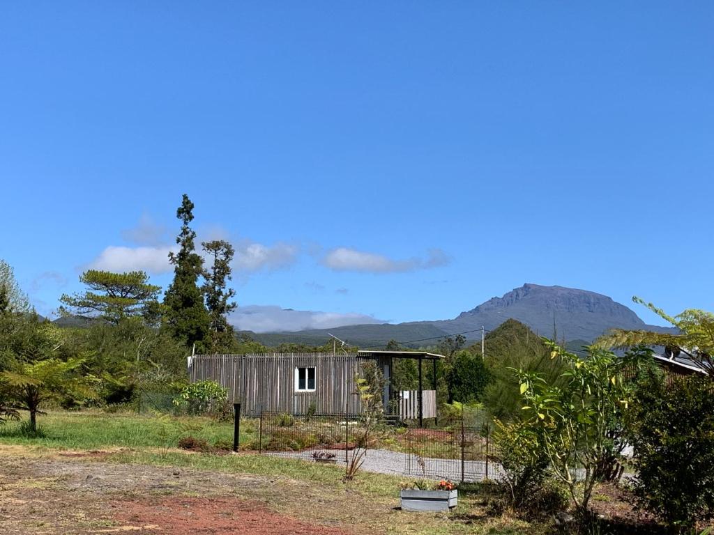a small shack in a field with mountains in the background at Les Capucines Adult Only in La Plaine des Palmistes