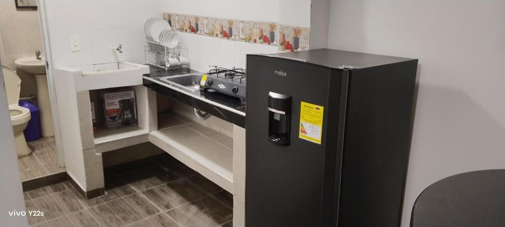 a black refrigerator in a kitchen next to a sink at Refugio Del Mar in Burrero