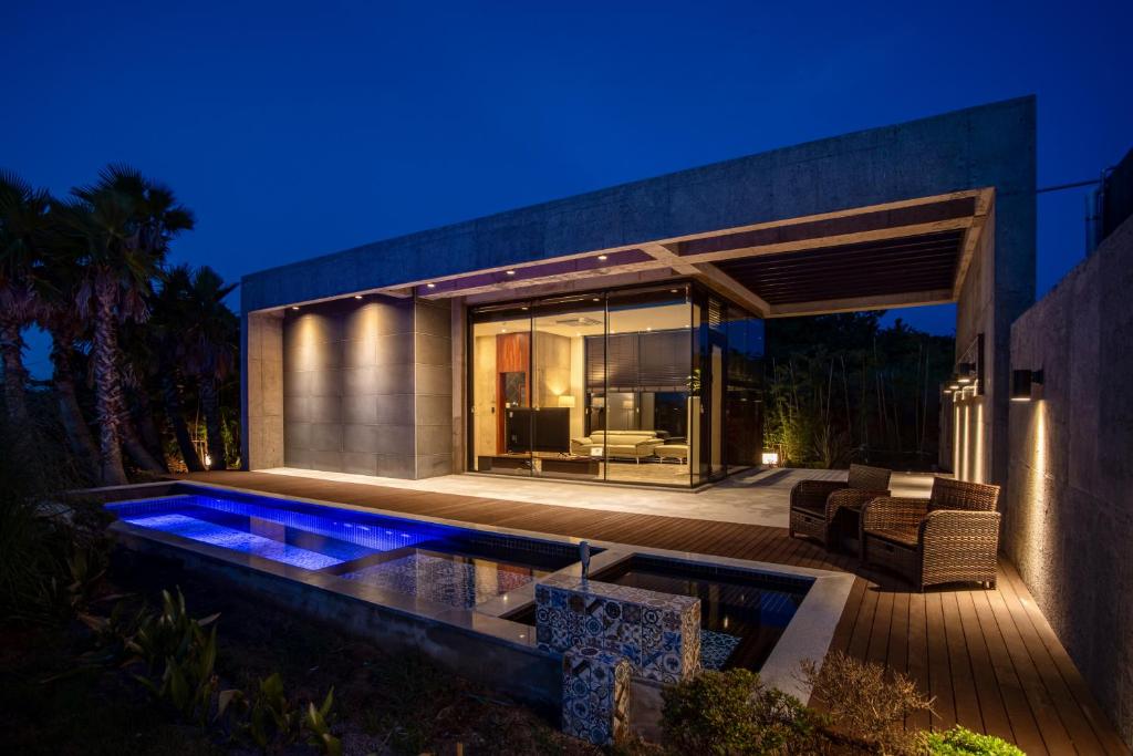 a house with a swimming pool at night at Ceylon Jeju Pool Villa in Jeju