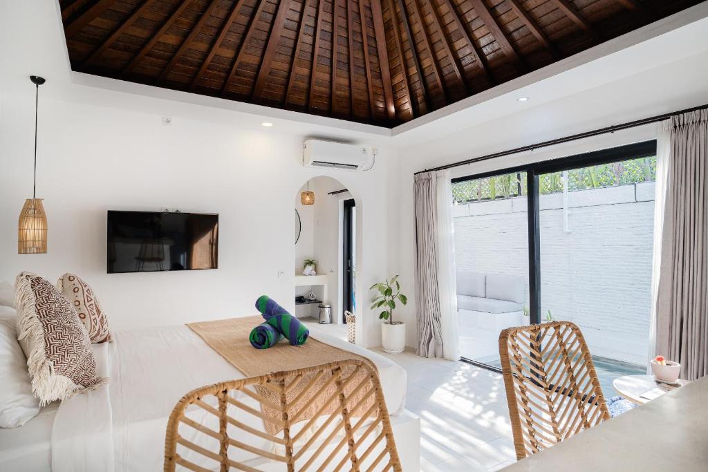 ein Wohnzimmer mit Tisch und Stühlen und einem Fernseher in der Unterkunft Villa Lotus - 1BR Canggu Villa with private pool - Near Wanderlust, Soma and BaliMMA in Dalung