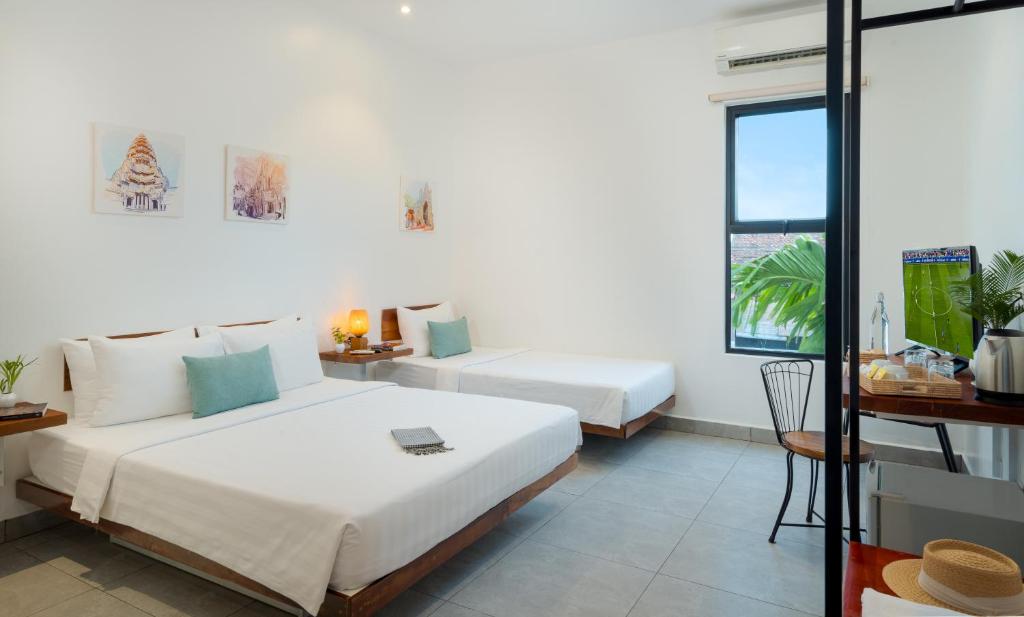 a hotel room with two beds and a window at Onederz Siem Reap in Siem Reap