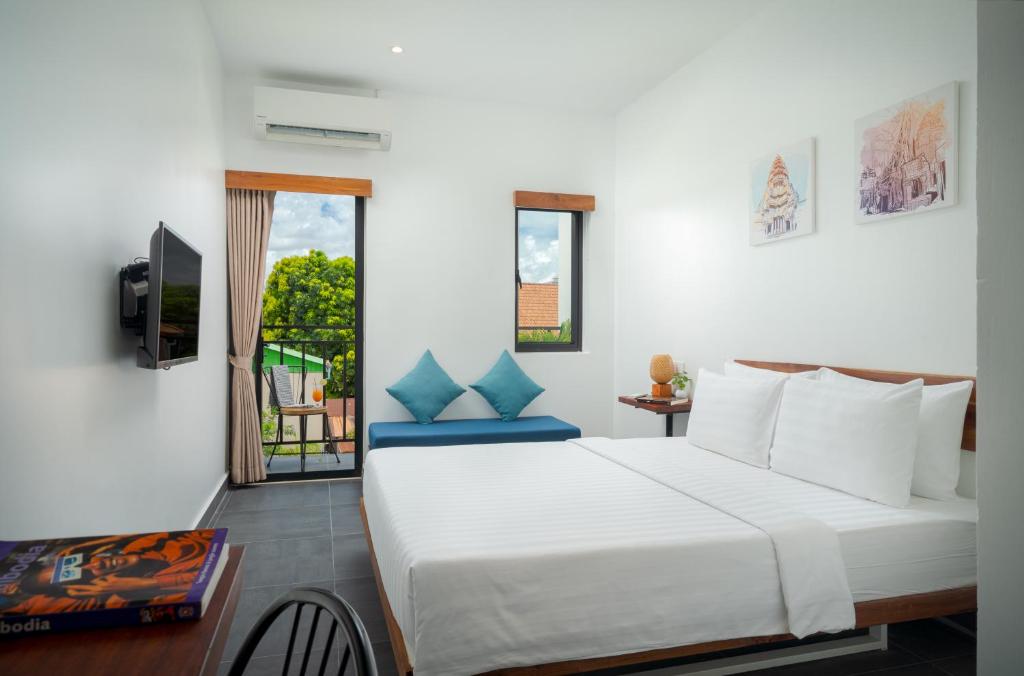 a bedroom with a large white bed and a window at Onederz Siem Reap in Siem Reap