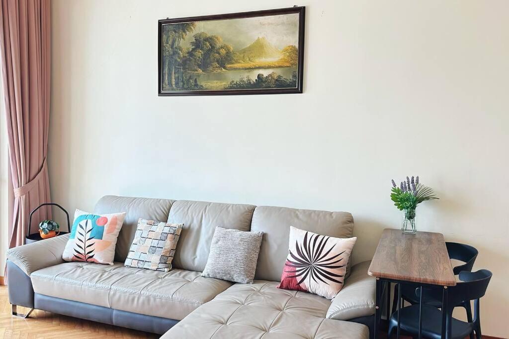 a living room with a couch with pillows on it at Straits Quay Highest Floor PoolView Suite in Tanjong Tokong