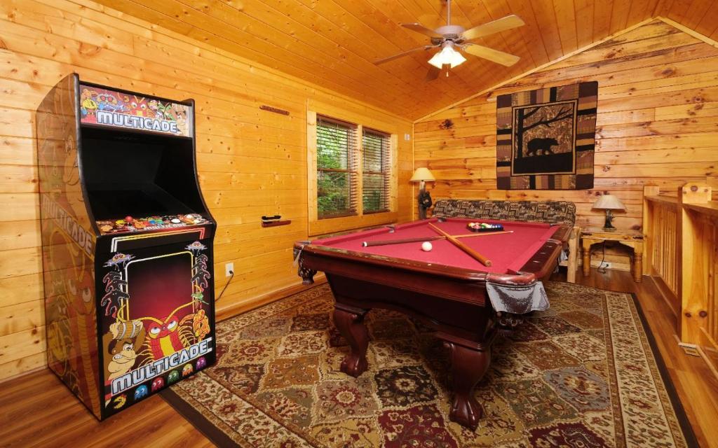 a living room with a pool table and a tv at Bear Retreat in Pigeon Forge