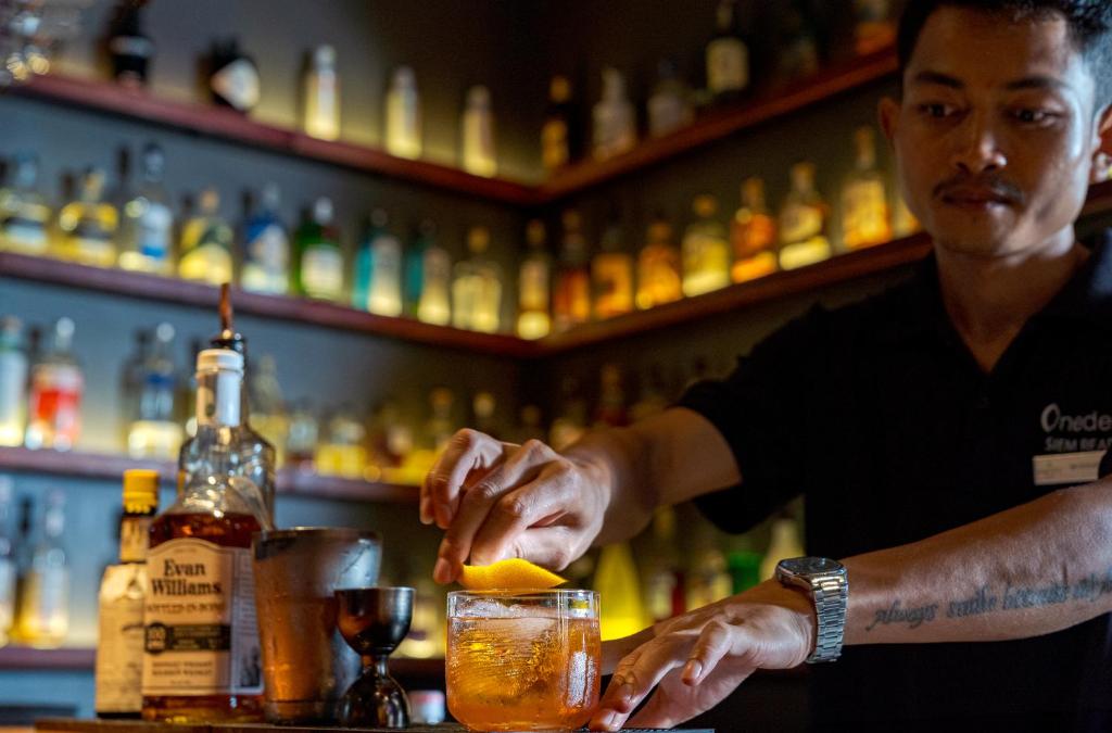 a man making a drink at a bar at Onederz Siem Reap in Siem Reap