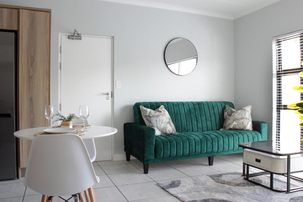 a living room with a green couch and a table at The Jade Escape in Cape Town