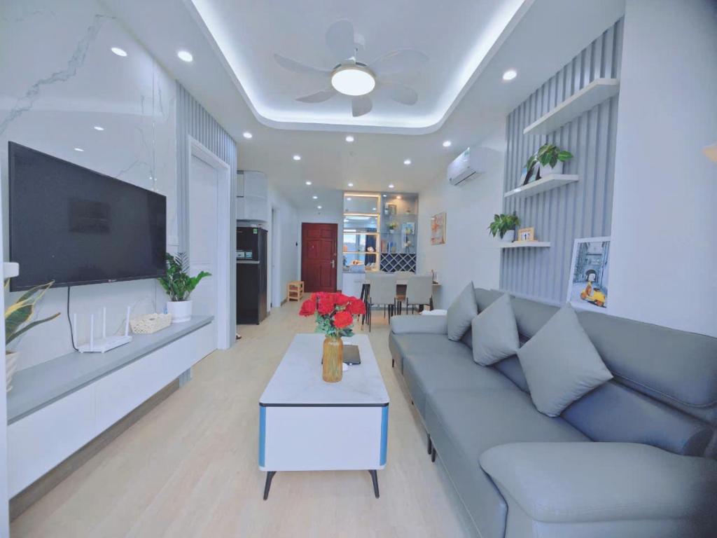 a living room with a couch and a tv at Homestay newlife Hạ Long in Ha Long