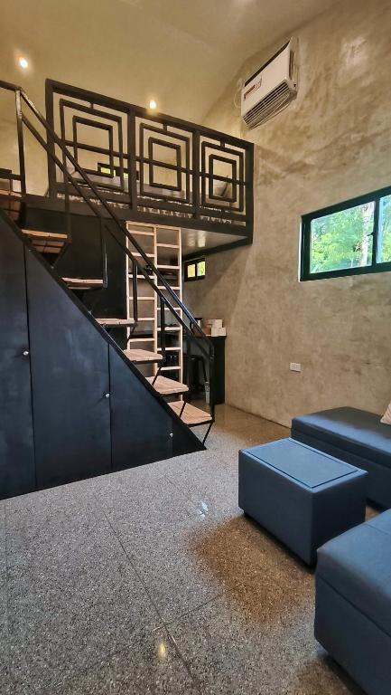 a living room with a staircase and a couch at El Nido Lofts in El Nido