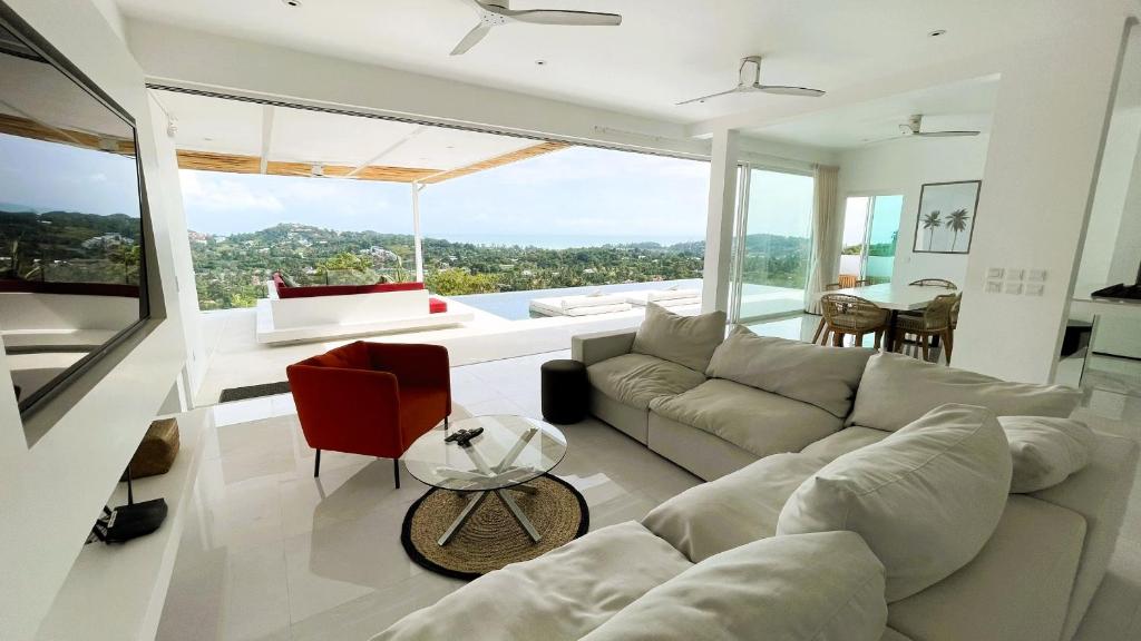 a living room with a couch and a table at Rockstarvillas - Villa Bob Dylan in Choeng Mon Beach