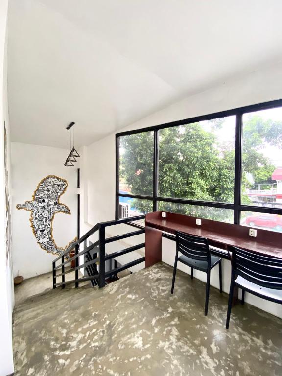 a room with a table and chairs and a large window at The Pocket Hotel in Mactan