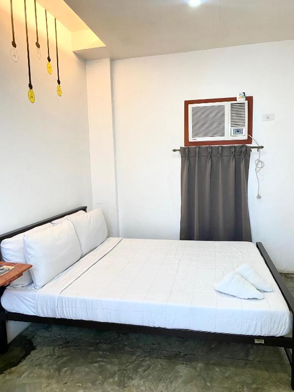 a bedroom with a bed with a air conditioner on the wall at The Pocket Hotel in Mactan
