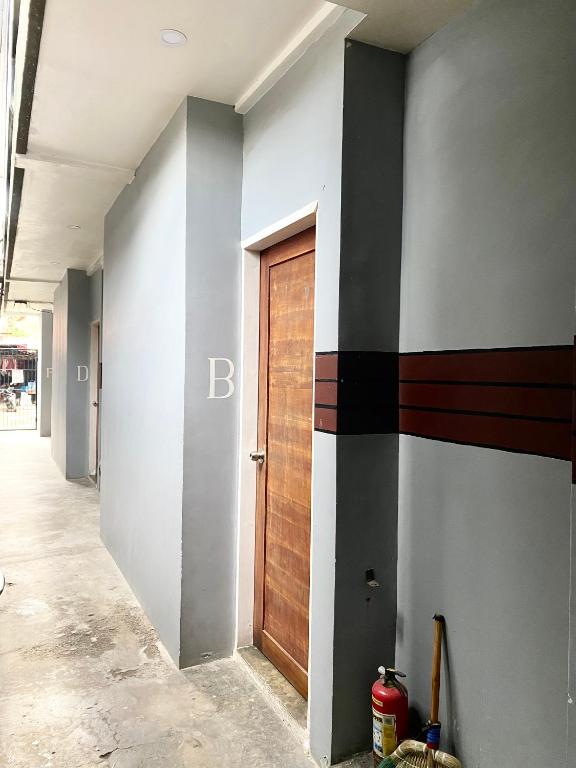 a hallway with a wooden door in a building at The Pocket Hotel in Mactan