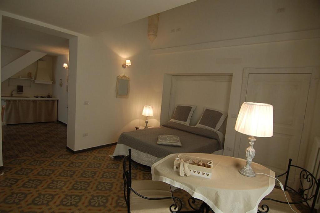 a bedroom with a bed and a table with a lamp at Domus Aurea in Martina Franca