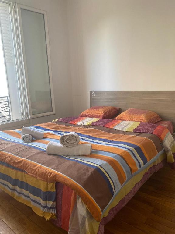 une chambre avec deux lits avec des serviettes dessus dans l'établissement Appartement porte de paris, à Bourg-la-Reine