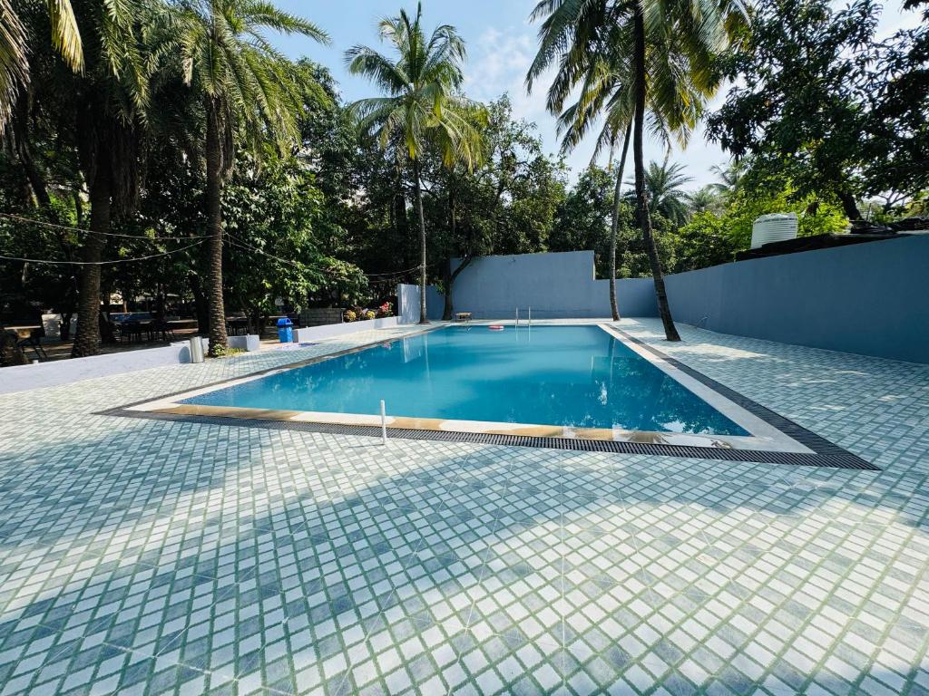 达曼Areca Palms Hotel & Resort的一座带瓷砖地板和棕榈树的游泳池