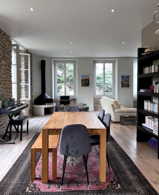 un salon avec une table et des chaises en bois dans l'établissement L'Ossau - Rare et Atypique - Parking Privé, à Pau
