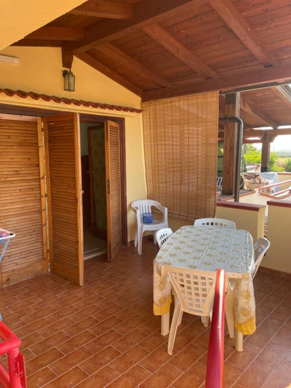 a room with a table and chairs on a patio at Appartamento nel Villaggio Carioca in Botricello