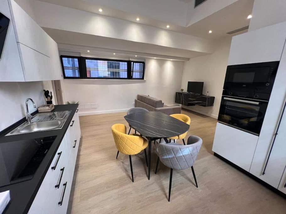 a kitchen with a table and chairs in a room at Castello Estense Luxury Apartment - Centro in Ferrara