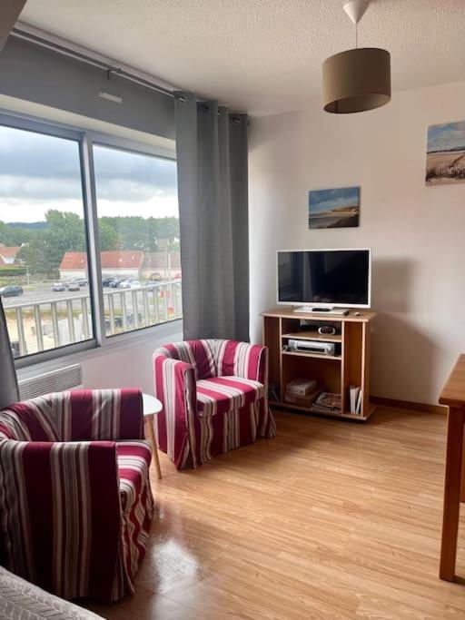 - un salon avec deux chaises et une télévision à écran plat dans l'établissement Duplex à 100m de la plage, à Neufchâtel-Hardelot