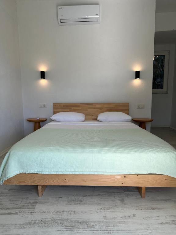 a bedroom with a wooden bed with two pillows at Blue Eye 5 km from AirPort Dalaman in Dalaman