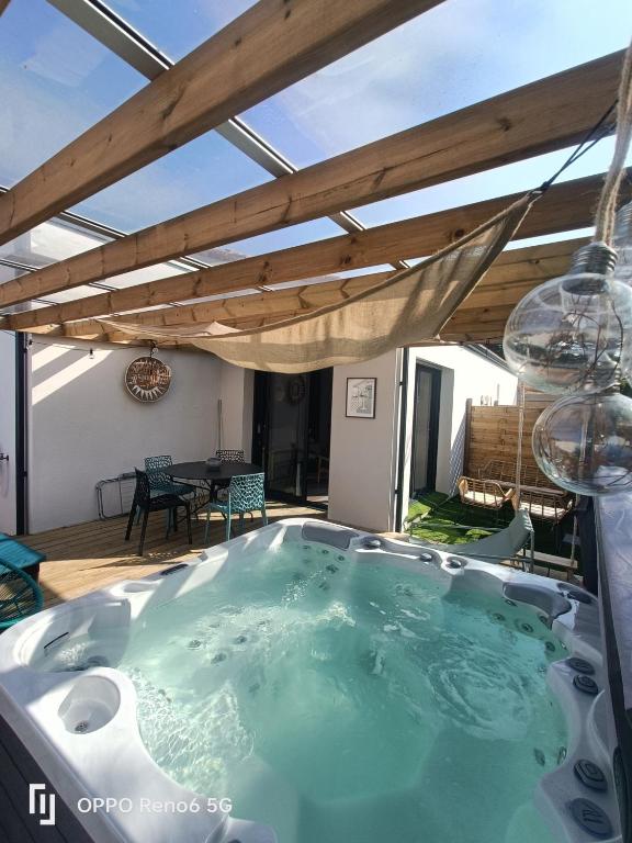 Un bain à remous est installé au milieu d'une terrasse. dans l'établissement Apb Spa locations avec jacuzzi privatif, à Saint-Jean-de-Monts