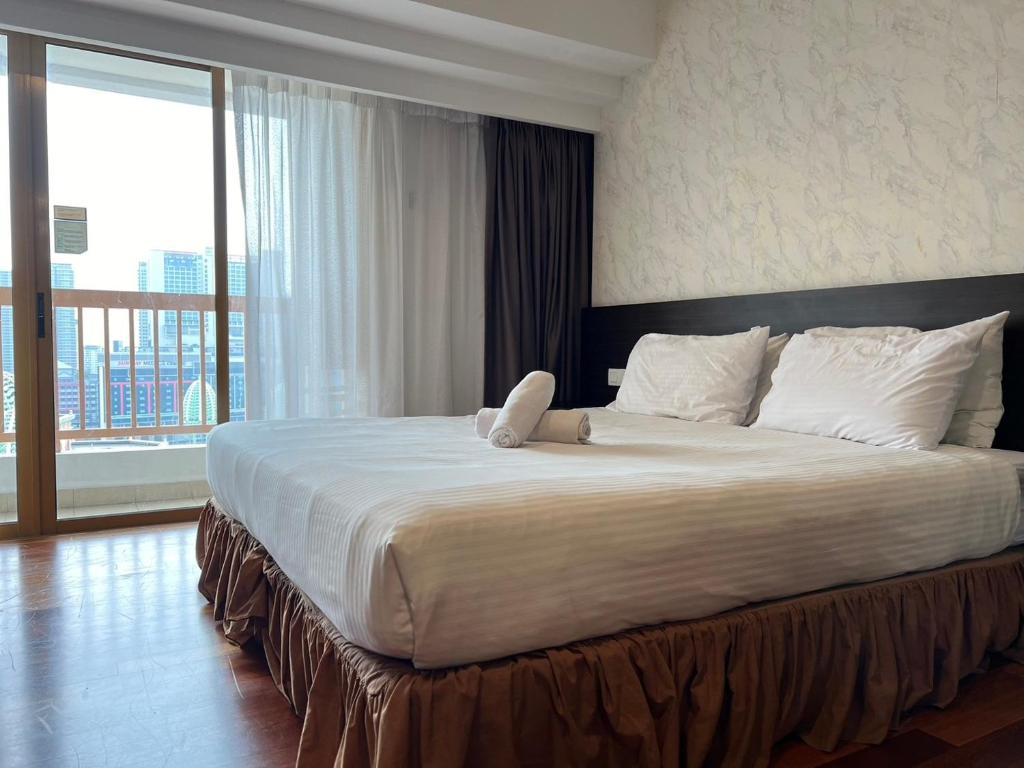 a bedroom with a large bed with a large window at Resort Suite Homestay By SunNest in Petaling Jaya
