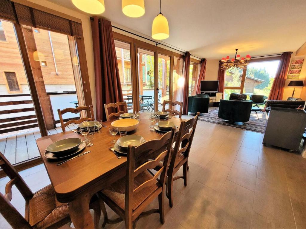 une salle à manger avec une table et des chaises en bois dans l'établissement Résidence Les OrÉades - Appartement à seulement 20m des pistes de la Turche MAE-3431, aux Gets