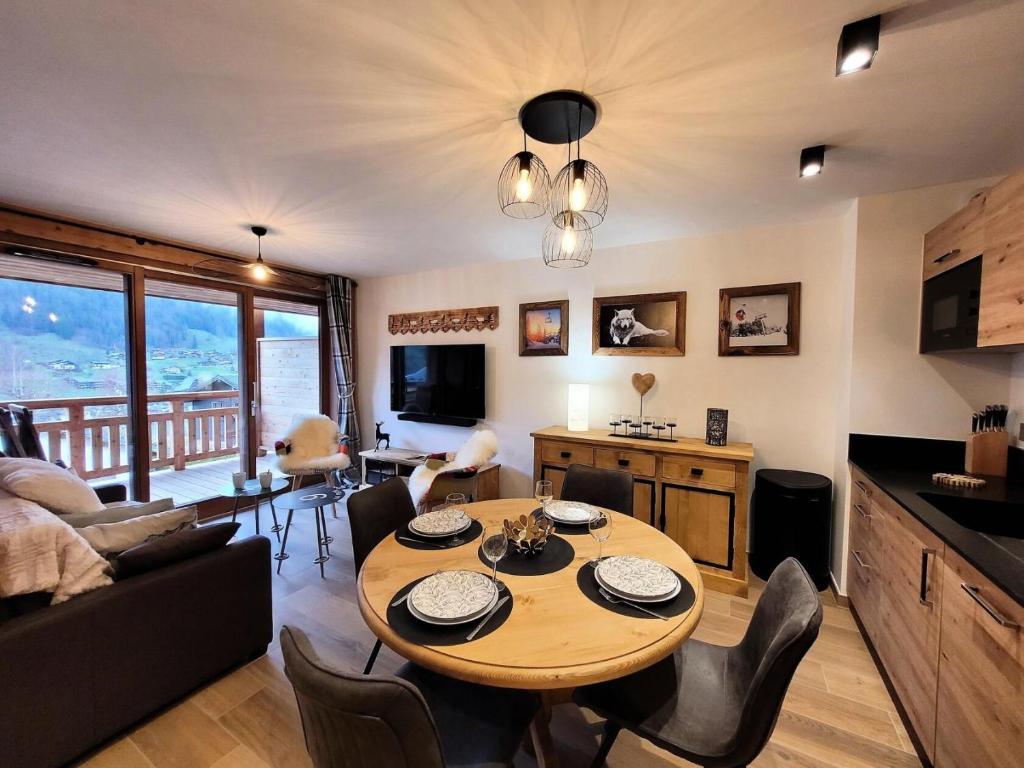 une cuisine et un salon avec une table et des chaises dans l'établissement Résidence Le Genepi - APPARTEMENT NEUF - 2 CHAMBRES EN SUITE AVEC VUE MAE-3501, aux Gets