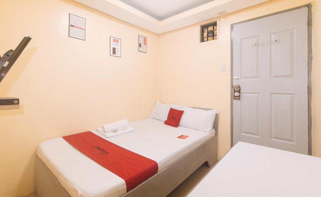a small room with a bed and a door at RedDoorz at LYOTO Bed and Breakfast near NAIA Terminal in Manila