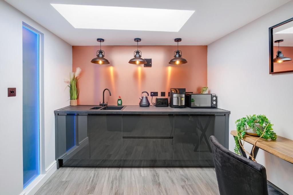 a kitchen with a black counter top in a room at Stanley Cottage, Greenford in Greenford