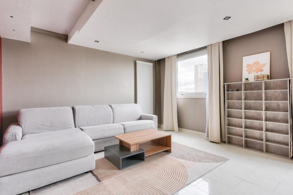 un salon avec un canapé et une table basse dans l'établissement Beautiful 1 bed flat at La Défense Near Metro 1, à Courbevoie