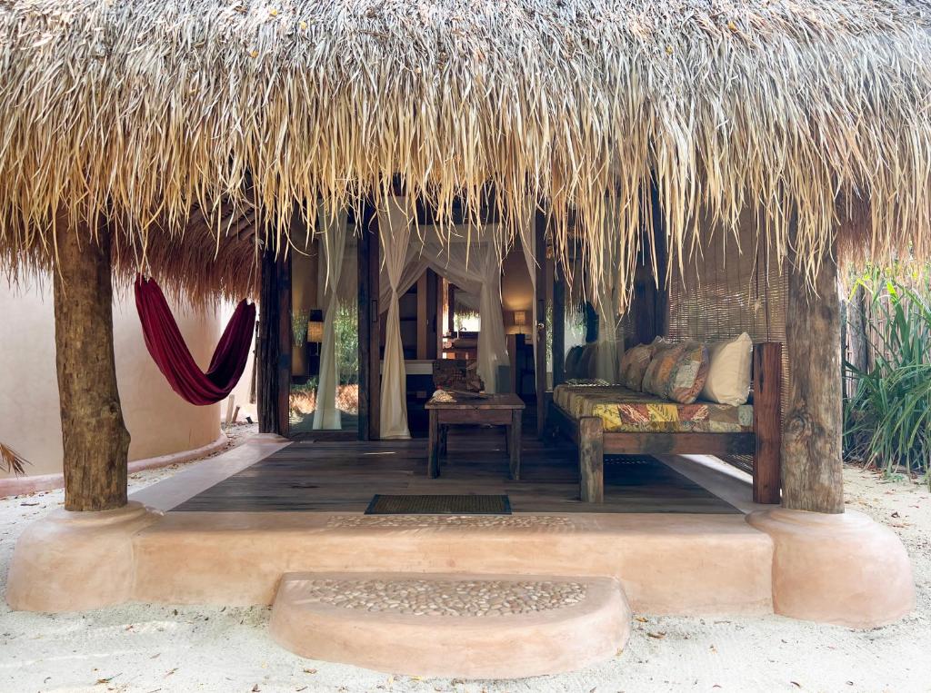a hut with a couch and a thatch roof at Gili Asahan Eco Lodge & Restaurant in Gili Asahan