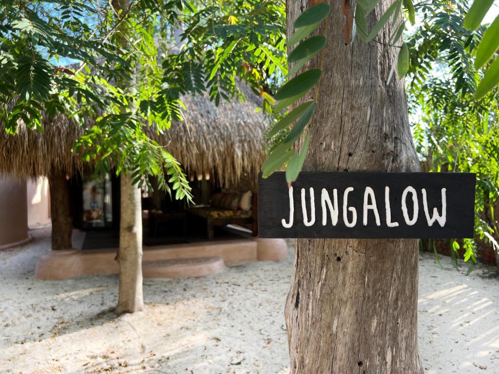 a sign on a tree that reads junkyahu at Gili Asahan Eco Lodge & Restaurant in Gili Asahan