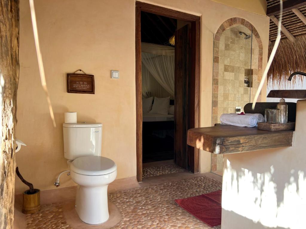 a bathroom with a toilet in a room at Gili Asahan Eco Lodge & Restaurant in Gili Asahan