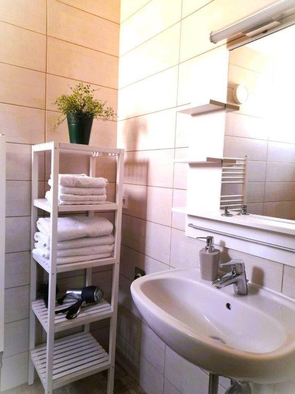 a bathroom with a sink and a white towel rack at Ferienwohnungen Halbturn in Halbturn