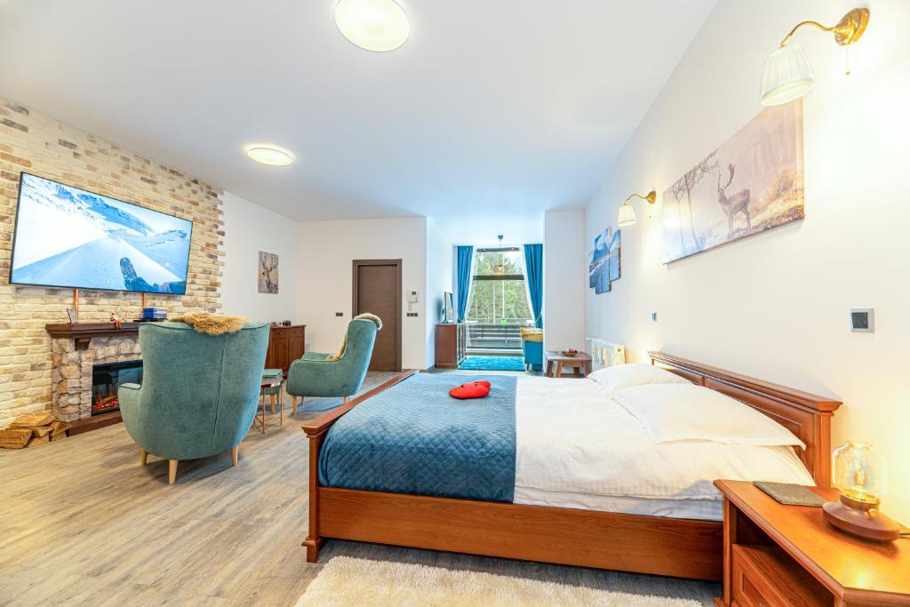 a bedroom with a king sized bed and a fireplace at Joy Studio - Poiana Brasov - Silver Resort in Poiana Brasov
