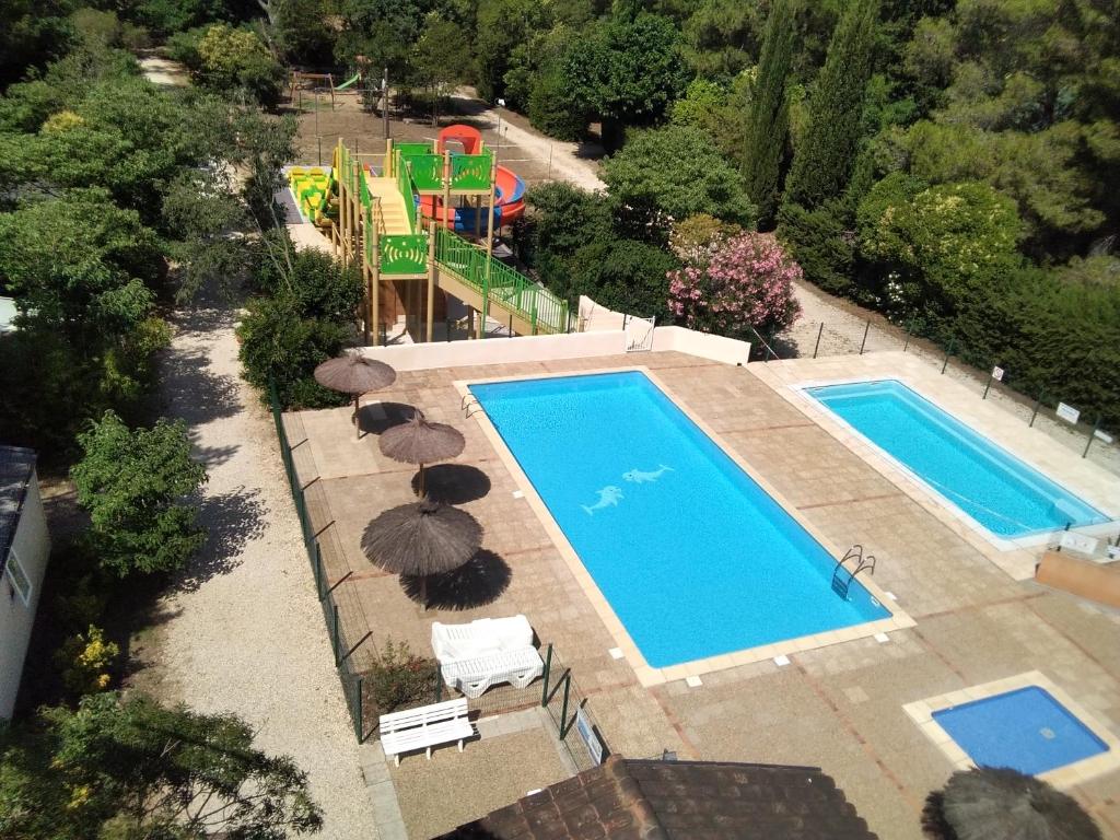 une vue aérienne d'une piscine avec parasols et chaises dans l'établissement Camping de la Chapelette, à Saint-Martin-de-Crau