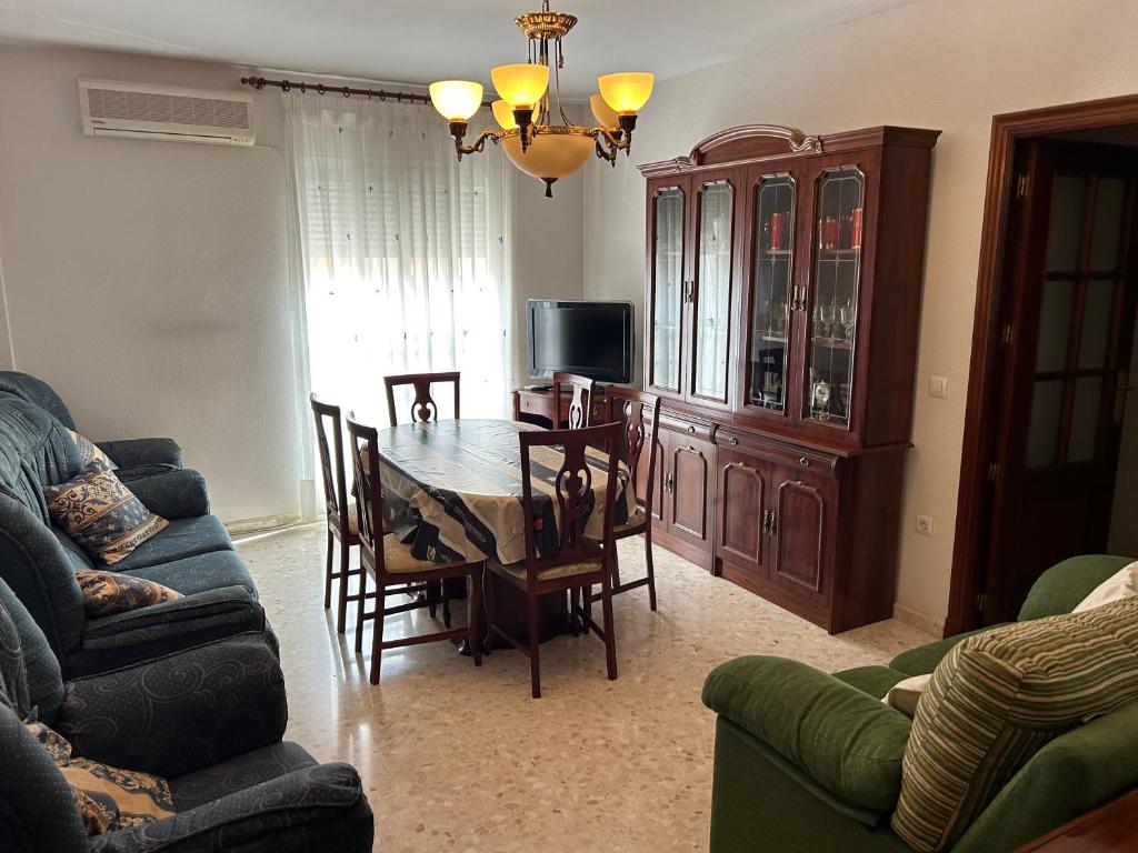 a living room with a table and chairs and a television at Piso completo, acogedor y cerca del centro in Baeza